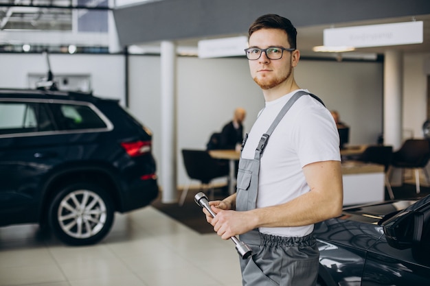 Free photo young mechanic with documents in car service