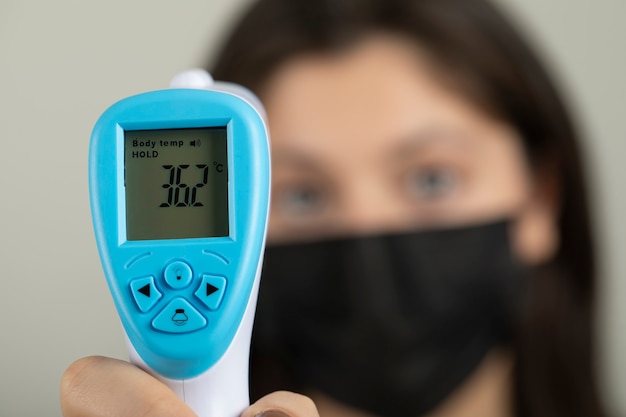 Young medical worker checking temperature.