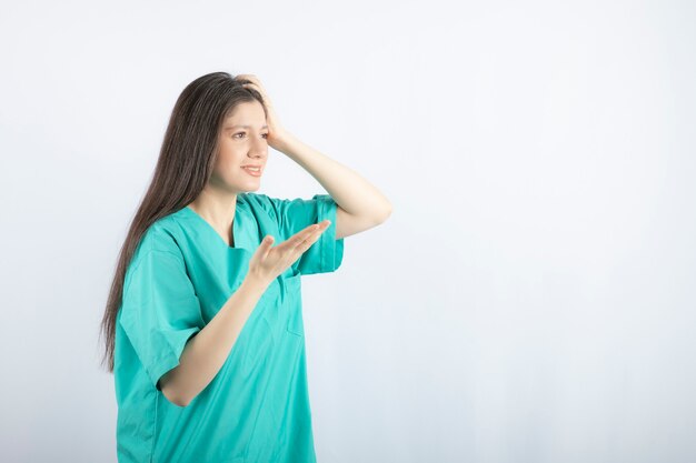 Young medical worker feeling sick and making a hand gesture.