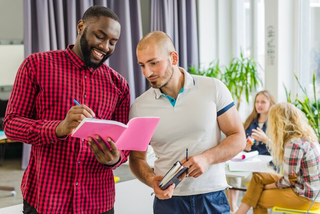 Young men collaborating with notepads