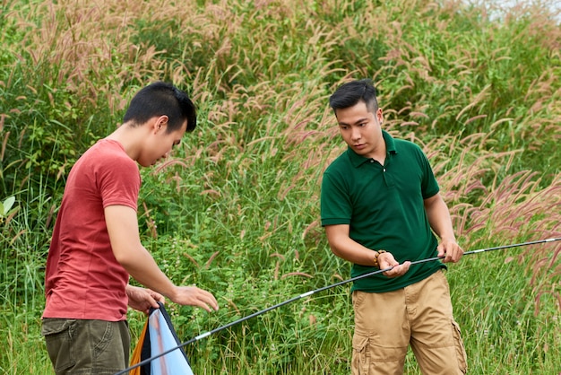 Young men setting tent