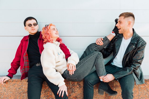 Young men sitting and supporting leaning smiling woman