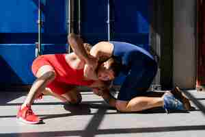 Free photo young men in sportswear demonstrating wrestling combat