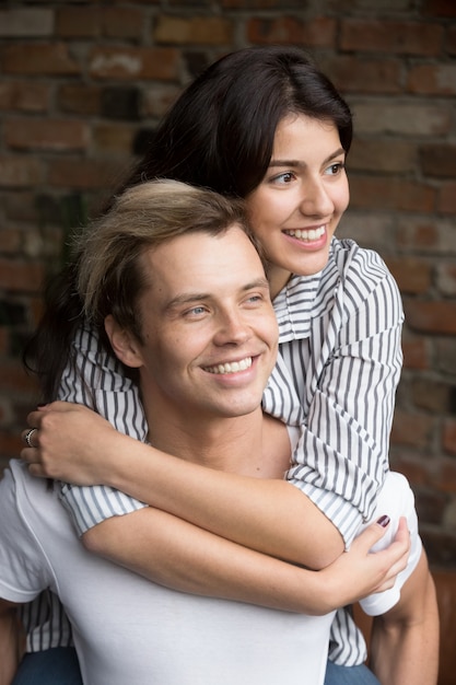 Young millennial couple in love embracing looking forward to future