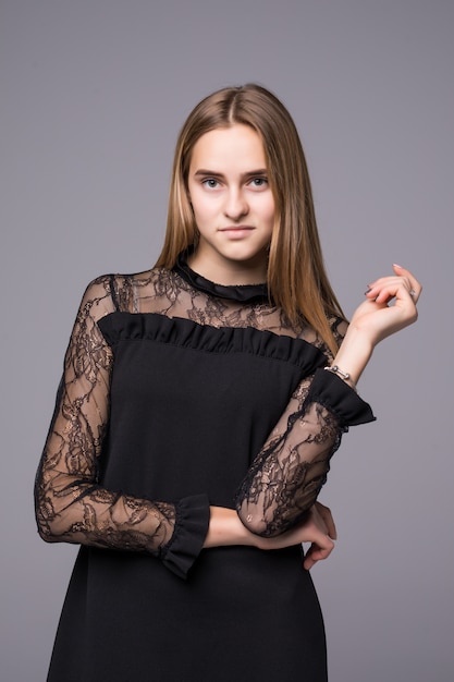 Young model in fashion dress posing on gray background