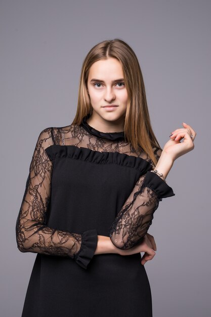 Young model in fashion dress posing on gray background