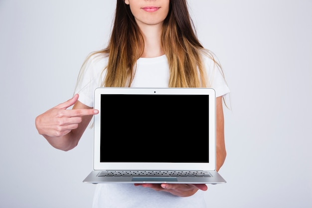 Young model holding and pointing laptop