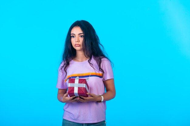 Young model holding a red gift box.