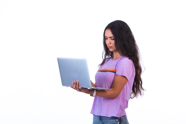 Young model holding a silver laptop and working. 