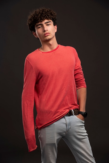 無料写真 キャスティングで自信を持ってポーズをとる赤いシャツの若いモデル。