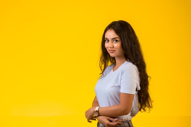 Young model posing at yellow wall.