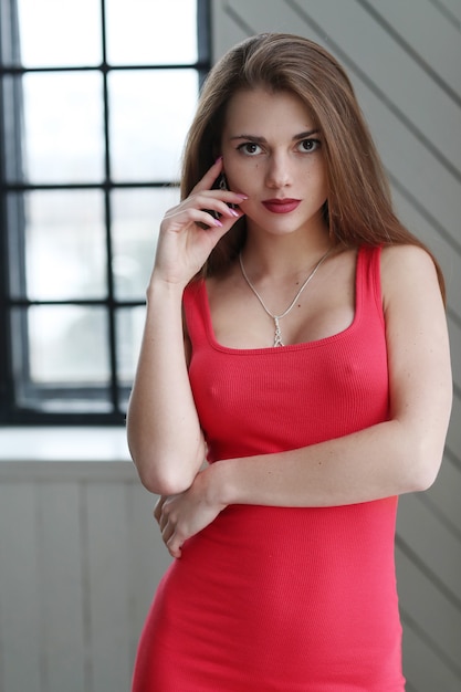 Юная модель в красном облегающем платье