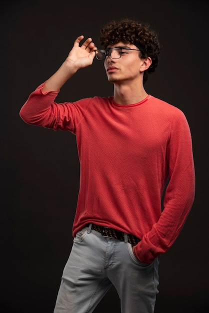 Young model in red shirt wearing eyeglasses. 