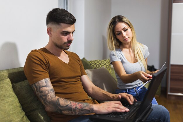 Young modern couple using laptop