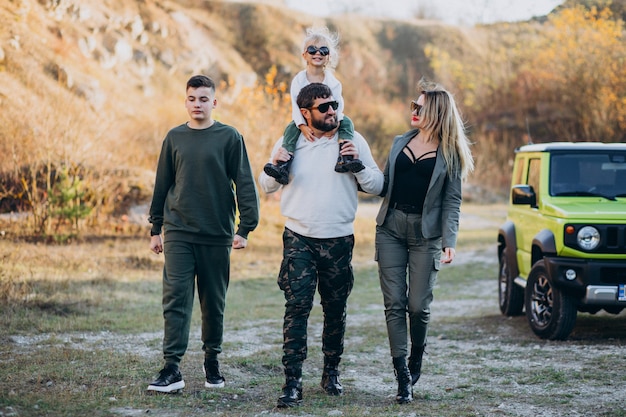 Young modern family travelling by car and stopped for a walk in park