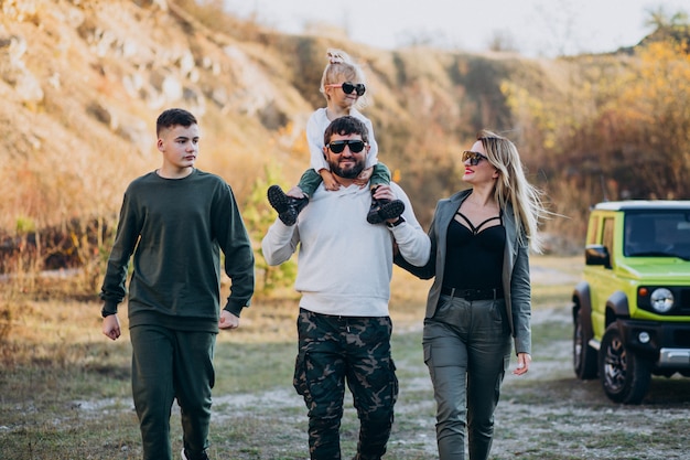 Young modern family travelling by car and stopped for a walk in park