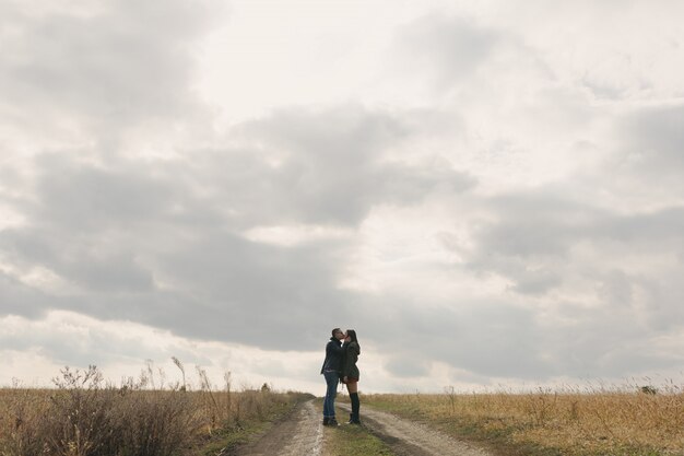 Young modern stylish couple outdoors. Romantic young couple in love outdoors in the countryside