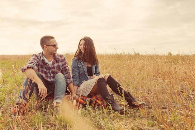 Young modern stylish couple outdoors. Romantic young couple in love outdoors in the countryside