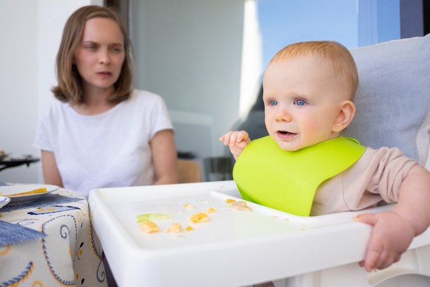 Giovane mamma che guarda bambino sveglio allegro