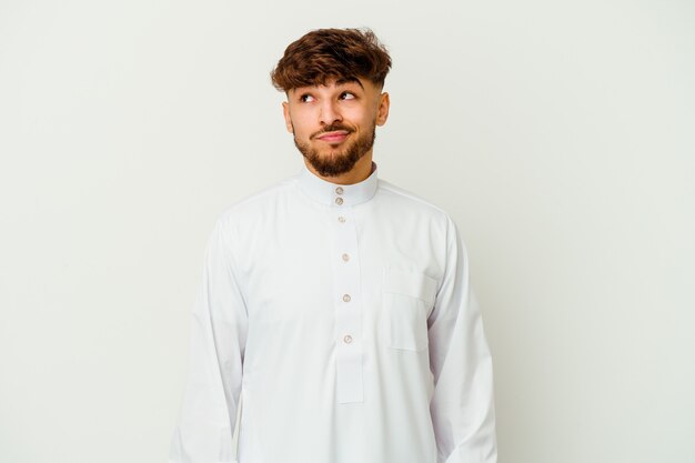 Young moroccan man wearing a typical arab clothes isolated on white wall confused, feels doubtful and unsure.