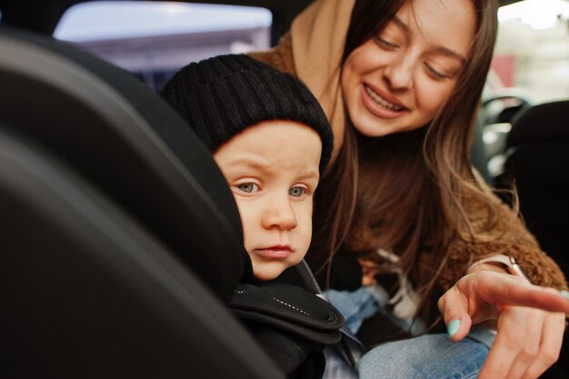 Young mother and child in car Baby seat on chair Safety driving concept