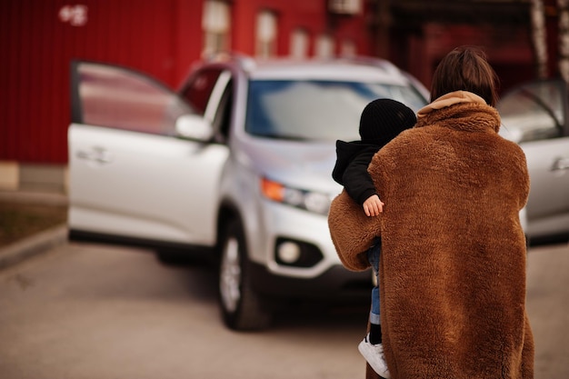 Free photo young mother and child stand near they suv car safety driving concept