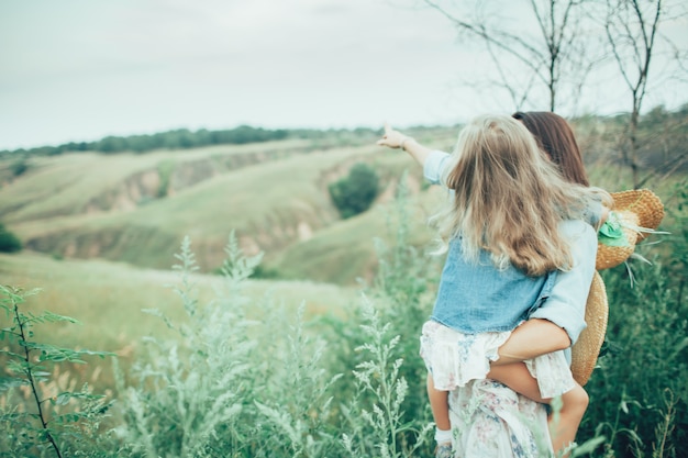 Free photo the young mother and daughter on green grass background