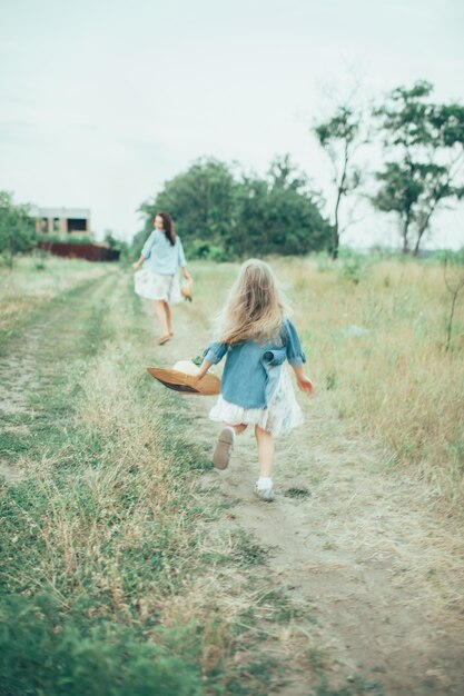 The young mother and daughter on green grass space