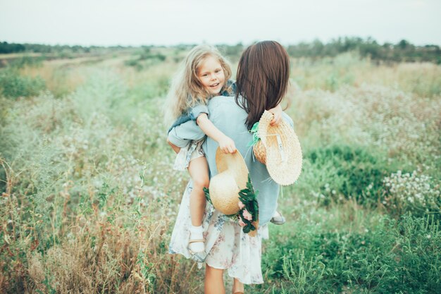 The young mother and daughter on green grass space