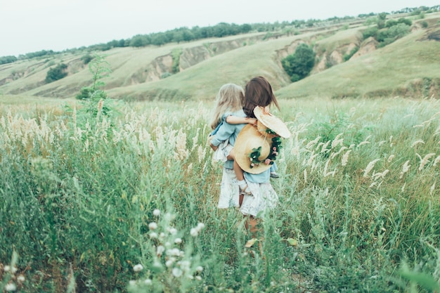 The young mother and daughter on green grass space