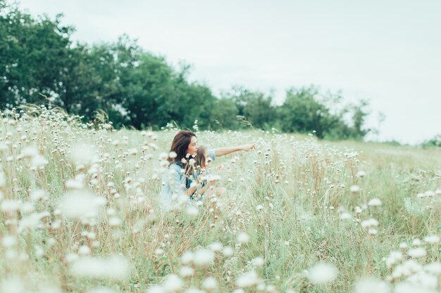 The young mother and daughter on green grass space