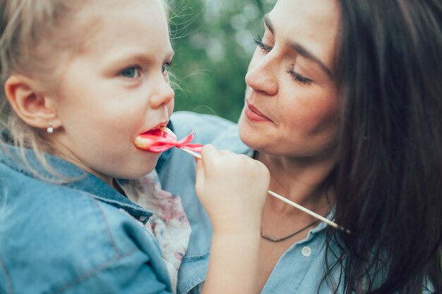 The young mother and daughter on green grass space