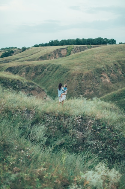 The young mother and daughter on green grass space