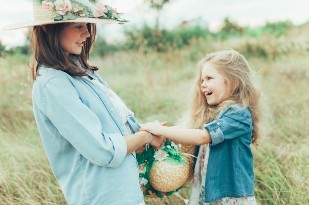 The young mother and daughter on green grass