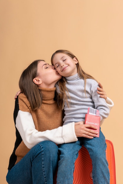 Young mother and daughter posing together before travel vacation