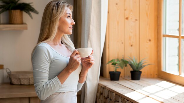 窓越しにコーヒーを楽しみながら若い母親