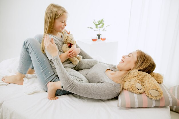 Young mother and her little daughter at home at sunny morning