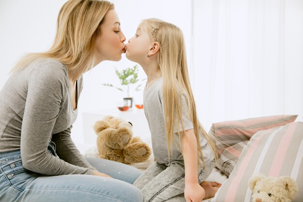 晴れた朝に家にいる若い母親と彼女の小さな娘