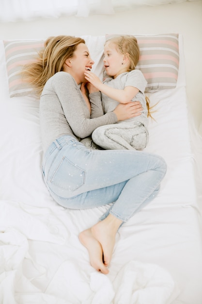 Giovane madre e la sua piccola figlia a casa al mattino pieno di sole