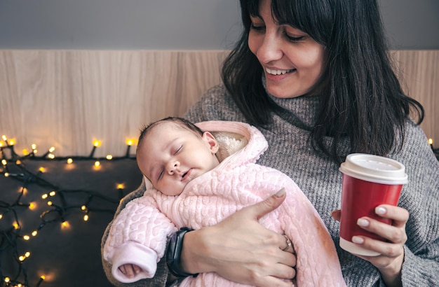 Free photo a young mother is sitting in a cafe with a newborn baby girl