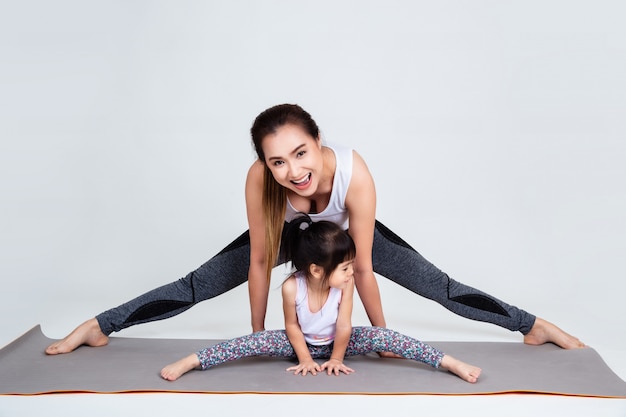 Молодая мама тренирует прекрасную дочь с гимнастикой