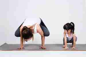 Foto gratuita giovane madre che prepara figlia adorabile con yoga