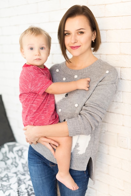 Foto gratuita giovane madre con il bambino sul braccio