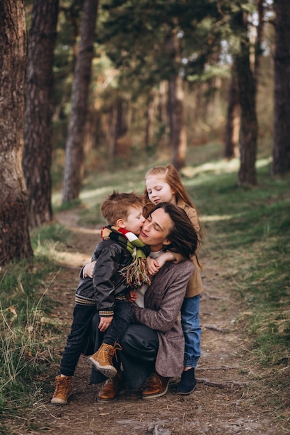 Young mother with daughter and son in forest