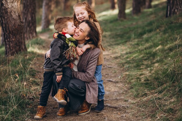 Young mother with daughter and son in forest