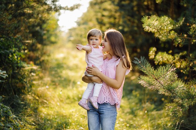 숲에서 그녀의 사랑스러운 작은 아기와 함께 젊은 어머니