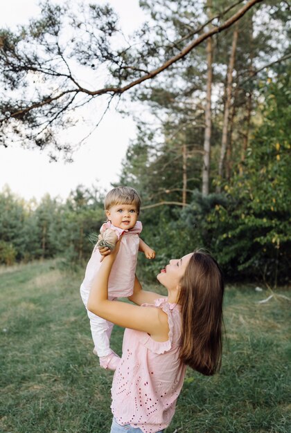 숲에서 그녀의 사랑스러운 작은 아기와 함께 젊은 어머니