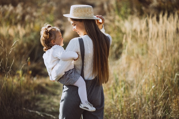 Молодая мать с маленькой дочерью в осеннем поле