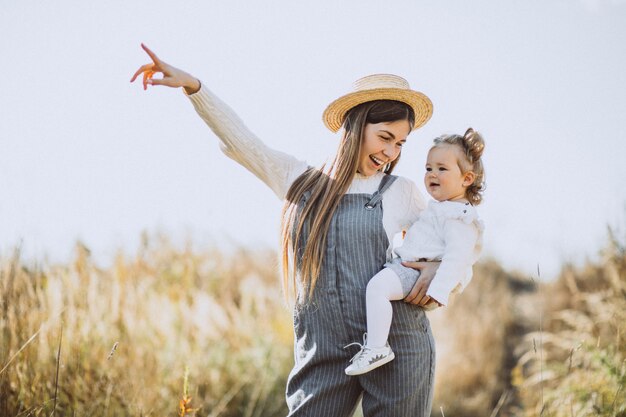 Young mother with her little daughter in an autumn field