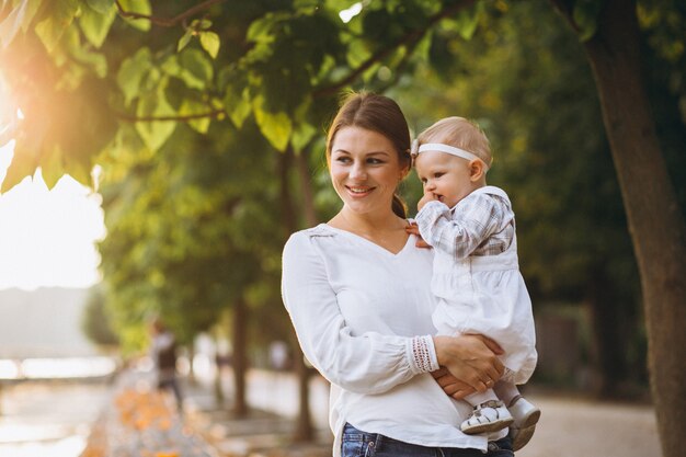 Young mother with her little daughter in an autumn park